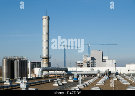 Fabrik-Rohre und Kräne auf dem Hintergrund des blauen Himmels. Stockfoto