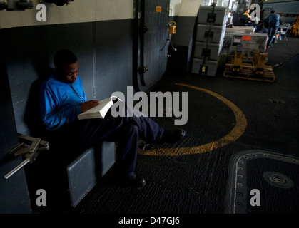 Luftfahrt Boatswain's Mate (Handling) Airman Krystina Brown studiert in der Hangar-Bucht an Bord eines Schiffes der US Navy im Arabischen Meer. Der Airman bereitet sich auf Wartungsaufgaben und Flugbetrieb vor. Stockfoto