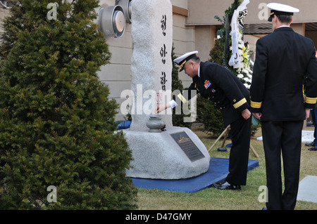 Hintere Adm. Ha Tae-min, stellvertretender Stabschef für Personal bei kombinierten Kräfte Befehl, Orte Weihrauch in einer Schüssel an der U.S. Navy Cheonan Denkmal als Hinten Adm. Bill McQuilkin, Kommandeur der Seestreitkräfte Korea, schaut an. Stockfoto