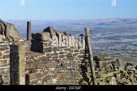 Stein-Stile in trockenen Steinwand auf den Gipfel Pendle Hill mit Blick auf Ingleborough & Pen-y-Gent in Yorkshire Dales Stockfoto