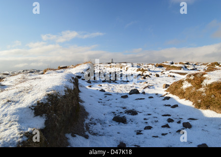 Wanderweg durch den Schnee & Torf Hags führt auf den Gipfel Trig Punkt Pendle Hill im Schnee an einem sonnigen Wintertag Stockfoto