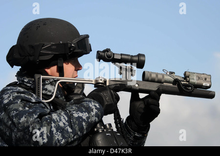 Ein Sailor an Bord der USS Forrest Sherman demonstriert den Einsatz eines Laser-Blendlichts während der Joint Warrior 2012 Übung. Der Laser-Blendschutz wird verwendet, um potenzielle Bedrohungen bei Marineoperationen vorübergehend zu desorientieren oder abzulenken. Stockfoto
