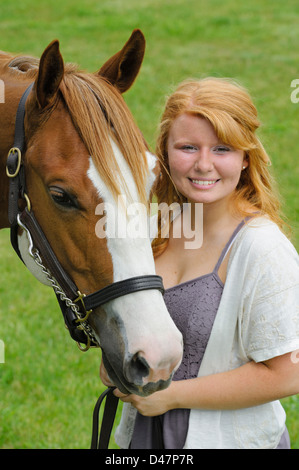 Lächelndes Mädchen mit ihrem Pferd im Portrait, Kopf geschossen rote behaarte Teenager und ihr Tier. Stockfoto