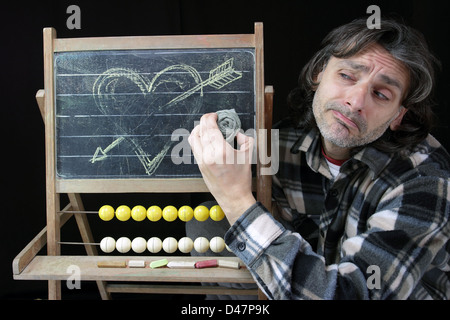 Ende der Liebe Konzept, trauriger Mann eine Herz Skizze auf Tafel löschen Stockfoto