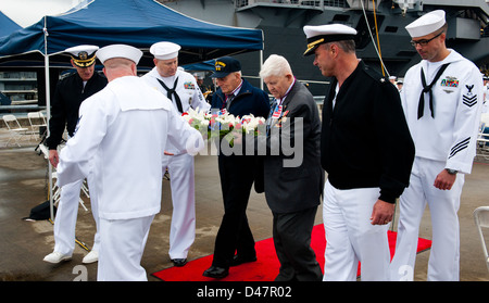 Segler zusammen mit Schlacht um Midway Veteranen tragen einen Kranz während einer Schlacht um Midway Gedenkfeier auf einem Pier am Marinestützpunkt Kitsap. Stockfoto