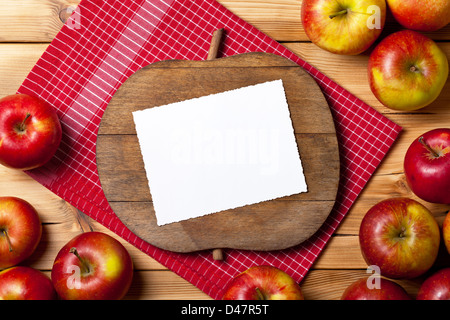 Äpfel auf Holztisch. Komposition mit frischen Früchten und Schneidebrett mit Apfel-Form. Leeren Raum für text Stockfoto