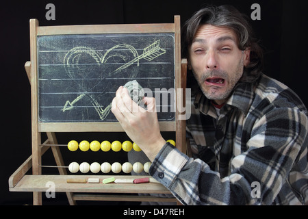 Ende der Liebe Konzept, trauriger Mann eine Herz Skizze auf Tafel löschen Stockfoto