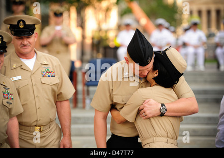 Die 2011 CNO Shore Sailor of the Year Chief Aircrew Survival Equipmentman Maria Johnson von Strike Fighter Squadron 131 wird von ihrem Mann am U.S. Navy Memorial umarmt, nachdem sie während der Pinning Ceremony mit voller Heiterlichkeit befördert wurde. Stockfoto