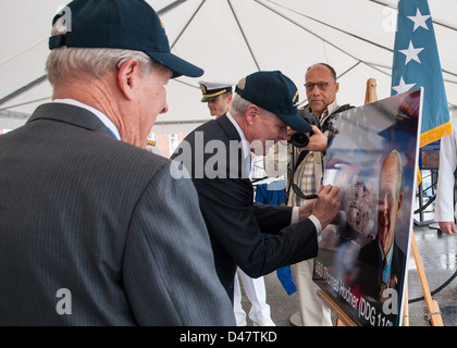 Der SECNAV unterschreibt eine grafische Veranschaulichung der USS Thomas Hudner während einer Namensgebung Feier. Stockfoto