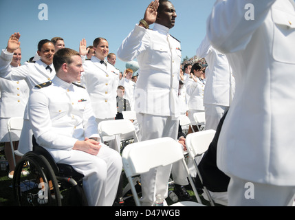 Ein Midshipmen 1st Class beobachtet, wie seine Klassenkameraden den Amtseid während der U.S. Naval Academy Class of 2012 Abschluss und Inbetriebnahme Zeremonie. Stockfoto
