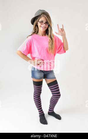 Niedlich und funky junge Teen Girl geben Haken Handzeichen mit Ball Cap und Gestreifte Kniestrümpfe Stockfoto