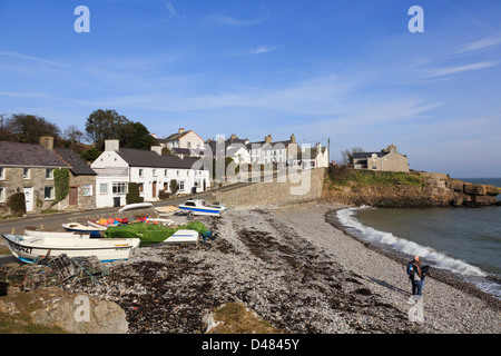 Direkt am Meer Ferienhäuser mit Boote am Kiesstrand in kleinen, alten Fischerdorf Moelfre, Isle of Anglesey, North Wales, UK, Großbritannien Stockfoto