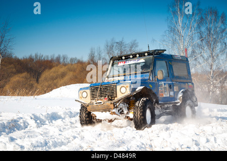 Blaue Land Rover Defender 90 Suv vorne auf Hintergrund der russische Winter. Stockfoto