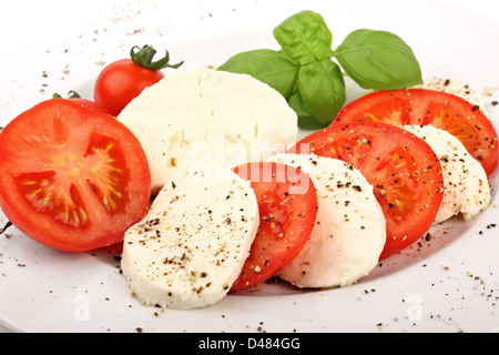 Mozzarella und Tomaten Scheiben mit Pfeffer und Basiliken. Stockfoto