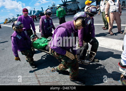 Matrosen transportieren ein simuliertes Patienten. Stockfoto