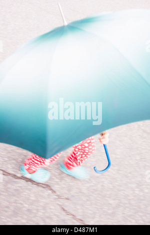 Kleines Mädchen mit gepunktete Hose mit großen Regenschirm Stockfoto