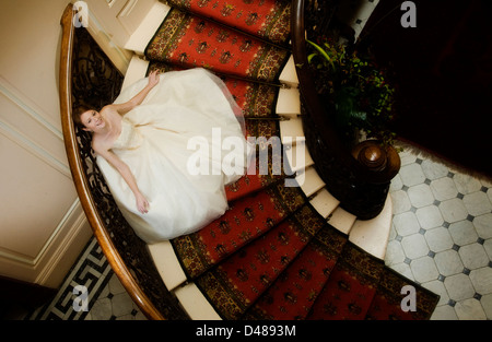 Braut auf verzierten Treppe mit voll mit Röckchen Creme trägerlosen Brautkleid von oben fotografiert Stockfoto