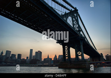 Silhouette der Manhattan Bridge über den East River mit Skyline bei Sonnenuntergang. Stockfoto