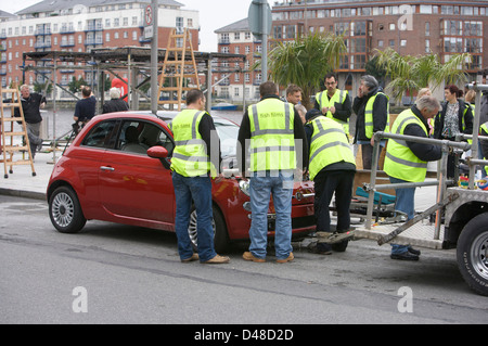 Rot Fiat 500 CC mit einem Film rig befestigt und Crew Vorbereiten des Fahrzeugs Stockfoto