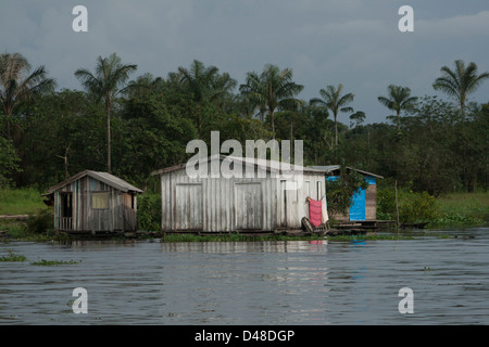 schwimmende Häuser und Menschen Rudern in kleinen Kanus in der Nähe von Manaus Stadt, Bundesstaat Amazonas, Nord-Brasilien. Stockfoto