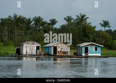 schwimmende Häuser und Menschen Rudern in kleinen Kanus in der Nähe von Manaus Stadt, Bundesstaat Amazonas, Nord-Brasilien. Stockfoto