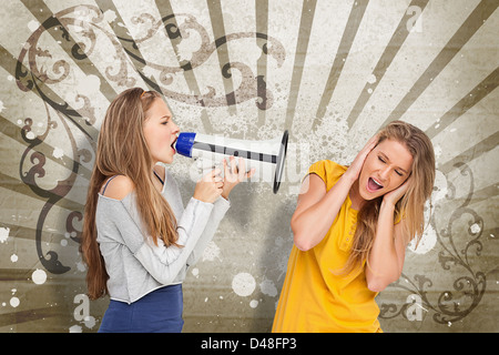 Mädchen an einem anderen durch ein Megaphon schreien Stockfoto