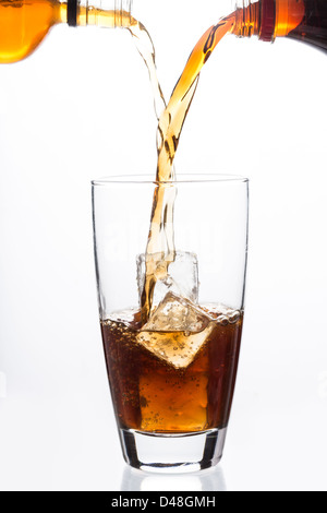 Zwei Flaschen in ein Glas mit Eiswürfel gießen Stockfoto