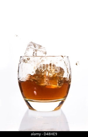 Eiswürfel in einem Tumbler Whiskey fallen Stockfoto