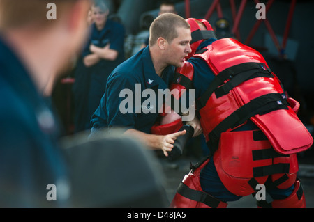 Ein Seemann kuppelt ein simulierter Angreifer während Sicherheitstraining. Stockfoto