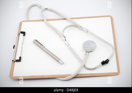 Stethoskop und Clip-Board mit leerem Papier auf weißem Hintergrund. Stockfoto