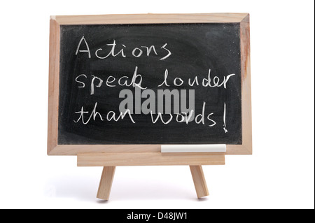 "Taten sprechen lauter als Worte" Spruch auf Tafel geschrieben auf weißem Hintergrund Stockfoto