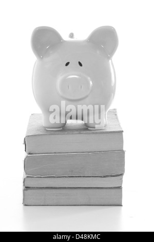 Piggy Bank stehend auf Stapel Bücher in schwarz / weiß Stockfoto