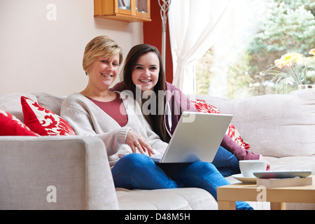 Mutter und Tochter genießen Surfen im Netz beim Entspannen zu Hause mit Kaffee Stockfoto