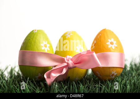 Drei Ostereier in rosa Schleife verpackt Stockfoto