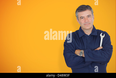 Ausgereifte Mechanik stehen vor gelbem Hintergrund Stockfoto