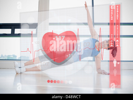 Frau Yoga beim betrachten futuristische Schnittstelle zeigt ihren Herzschlag zu tun Stockfoto