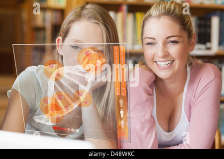 Zwei lächelnde Studenten auf der Suche auf Laptop und futuristische interface Stockfoto