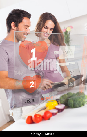 Lächelnde paar Vorbereitung Abendessen mit futuristischen Schnittstelle Stockfoto