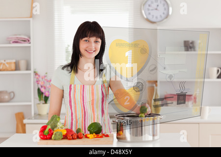 Lächelnde Frau Abendessen mit Hologramm-Schnittstelle Stockfoto