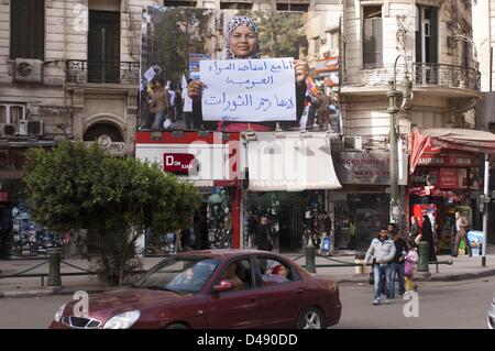 Kairo, Ägypten. 8. März 2013. Ein Banner mit der ägyptischen Aktivisten SAMIRA IBRAHIM hängt in Kairos Talaat Harb Square kurz vor einem März Internationaler Frauentag Tag 2013 am Freitag. Auf dem Schild hält sie im Banner steht, "ich bin mit dem Aufstand der arabischen Frauen." Ibrahim kam nach vorn, nachdem sie und andere Demonstranten Jungfräulichkeitstests während, von der Armee verhaftet ausgesetzt waren. (Bild Kredit: Kredit: Cliff Cheney/ZUMAPRESS.com/Alamy Live-Nachrichten) Stockfoto