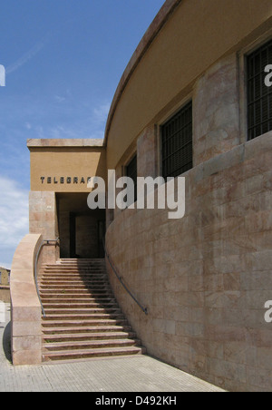 Der Palazzo delle Poste di Agrigento in Sizilien, der von Angiolo Mazzoni zwischen 1932 und 1934 entworfen wurde, ist ein wichtiges Beispiel für die Architektur der Faschistischen Ära. Das Gebäude verbindet Rationalismus mit monumentalem Design, mit einer großen Treppe und starken geometrischen Formen, die den architektonischen Stil der Zeit widerspiegeln. Stockfoto
