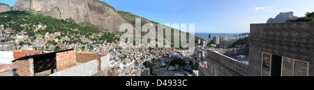 Die Favela da Rocinha in Rio de Janeiro, eine der größten informellen Siedlungen Brasiliens, zeigt die komplexe Stadtlandschaft der Stadt. Der Panoramablick unterstreicht den Kontrast zwischen den dicht gepackten Häusern und der umliegenden Stadtlandschaft. Die Favela stellt eine ständige Herausforderung in der Stadtplanung dar, deren Ziel es ist, die Lebensbedingungen zu verbessern. Stockfoto