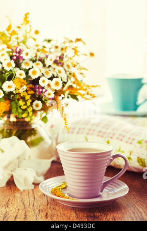 Morgentee und hellen Wildblumen Stockfoto