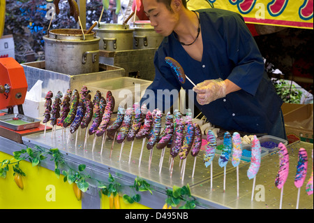 Ein Lebensmittel-Anbieter auf einem Festival in Japan verkauft Schokolade Bananen mit vielfarbigen bedeckt streut... Yum! Stockfoto