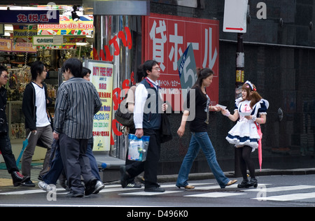 Mädchen, gekleidet in Französisch Dienstmädchen Kostüme Rabatt-Coupons für Maid Cafés in Tokio Akihabara Vergnügungsviertel austeilen. Stockfoto