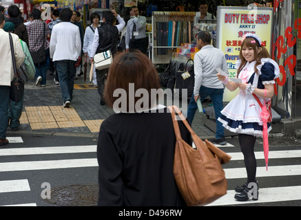 Mädchen, gekleidet in Französisch Dienstmädchen Kostüme Rabatt-Coupons für Maid Cafés in Tokio Akihabara Vergnügungsviertel austeilen. Stockfoto