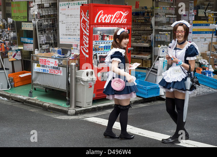 Mädchen, gekleidet in Französisch Dienstmädchen Kostüme Rabatt-Coupons für Maid Cafés in Tokio Akihabara Vergnügungsviertel austeilen. Stockfoto