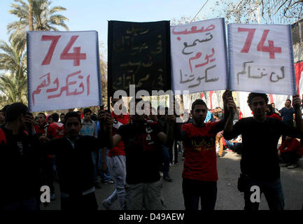 Kairo, Ägypten. 8. März 2013.  Ägyptische Fußball-Fans von Al-Ahly Club feiern vor ihrem Clublokal in Kairo. Eine ägyptische Gericht bestätigte Todesurteile gegen 21 Personen für ihre Rolle in eine tödliche 2012 Fußball-Aufstand, der mehr als 70 Menschen in der Stadt Port Said getötet. Banner im Hintergrund zeigt einige Bilder von den Opfern mit Arabisch, die liest, '' Wir werden dich nie vergessen (Bild Kredit: Kredit: Tareq Gabas/APA Images/ZUMAPRESS.com/Alamy Live News) Stockfoto