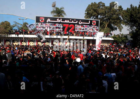 Kairo, Ägypten. 8. März 2013.  Ägyptische Fußball-Fans von Al-Ahly Club feiern vor ihrem Clublokal in Kairo. Eine ägyptische Gericht bestätigte Todesurteile gegen 21 Personen für ihre Rolle in eine tödliche 2012 Fußball-Aufstand, der mehr als 70 Menschen in der Stadt Port Said getötet. Banner im Hintergrund zeigt einige Bilder von den Opfern mit Arabisch, die liest, '' Wir werden dich nie vergessen (Bild Kredit: Kredit: Tareq Gabas/APA Images/ZUMAPRESS.com/Alamy Live News) Stockfoto