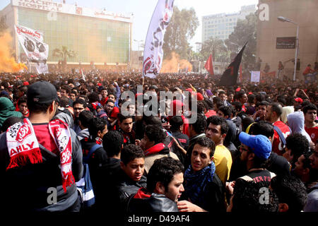 Kairo, Ägypten. 8. März 2013.  Ägyptische Fußball-Fans von Al-Ahly Club feiern vor ihrem Clublokal in Kairo. Eine ägyptische Gericht bestätigte Todesurteile gegen 21 Personen für ihre Rolle in eine tödliche 2012 Fußball-Aufstand, der mehr als 70 Menschen in der Stadt Port Said getötet. Banner im Hintergrund zeigt einige Bilder von den Opfern mit Arabisch, die liest, '' Wir werden dich nie vergessen (Bild Kredit: Kredit: Tareq Gabas/APA Images/ZUMAPRESS.com/Alamy Live News) Stockfoto